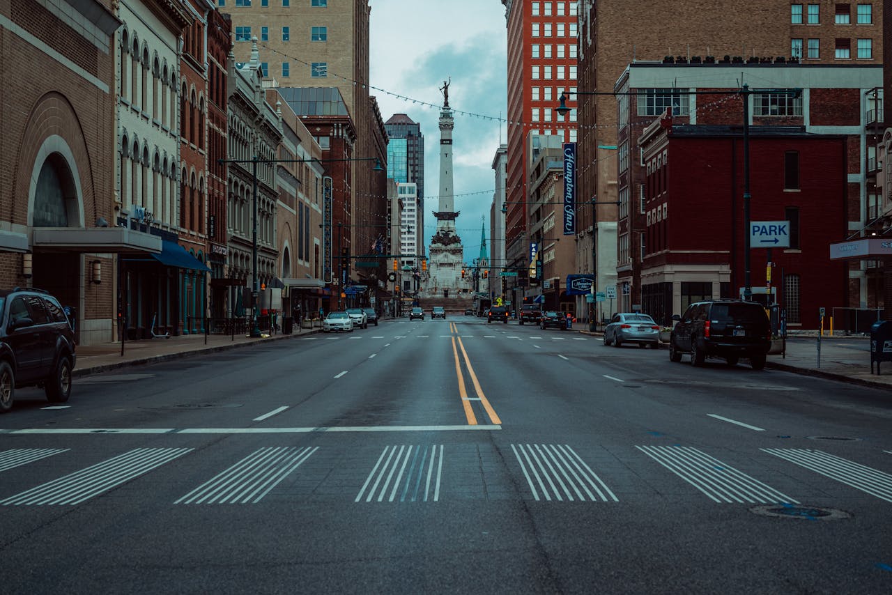 Urban street view featuring a prominent city monument with an empty road and surrounding architecture.